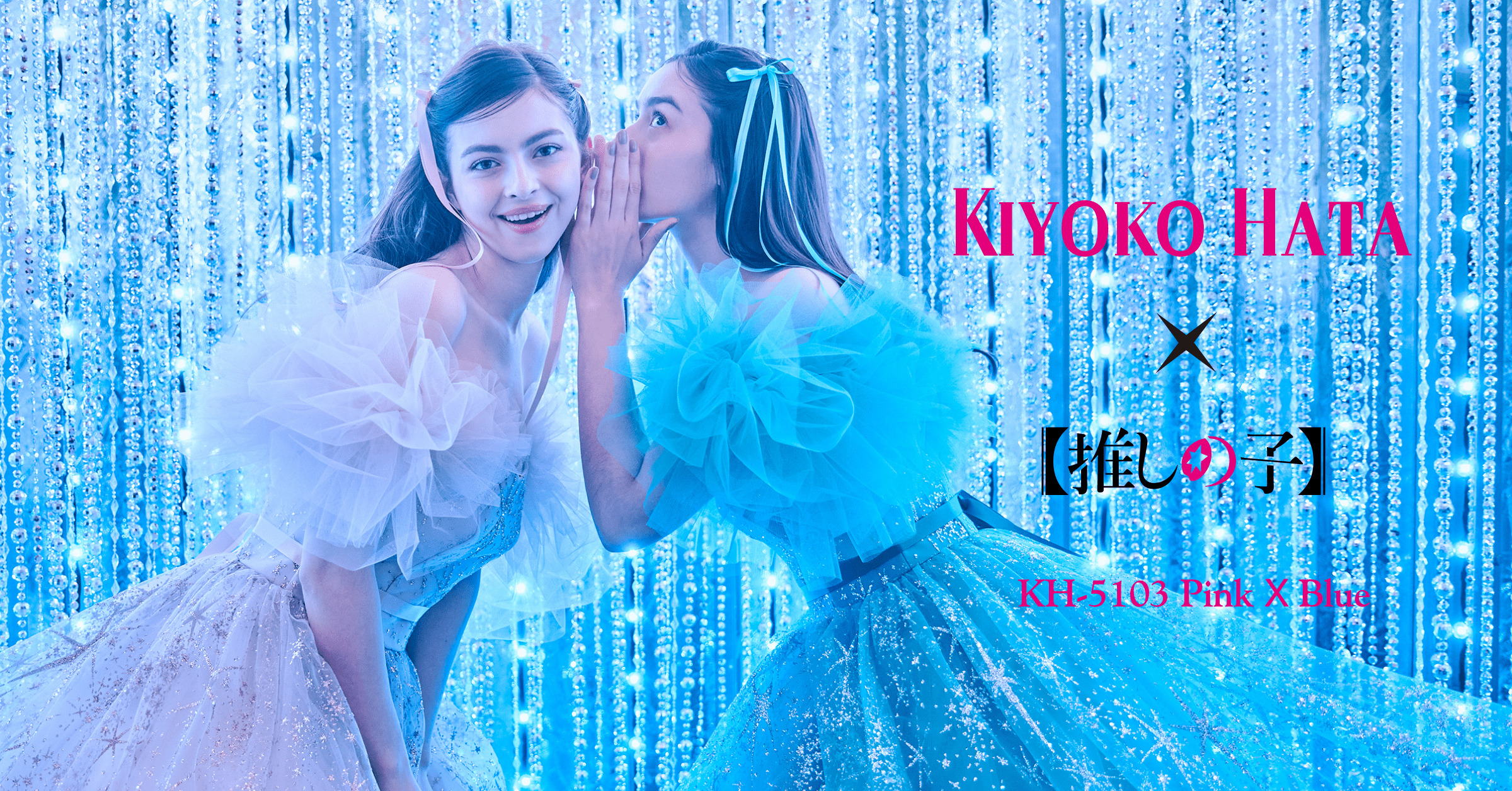 ブルーのドレスを着た女性モデルが、ピンクのドレスを着た女性モデルの左耳に囁きかけている。右側には『KIYOKO HATA』と『推しの子』のロゴが並び、両者のコラボレーションを表現している。